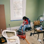 Sue on her scooty cart painting baseboards.