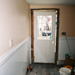 Hanging a new exterior door in the kitchen. You can see from the gap on the right-hand side the kinds of shimming we had to do throughout the entire project.