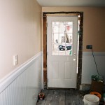 Hanging a new exterior door in the kitchen. You can see from the gap on the right-hand side the kinds of shimming we had to do throughout the entire project.